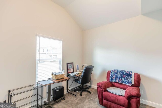 carpeted home office featuring lofted ceiling