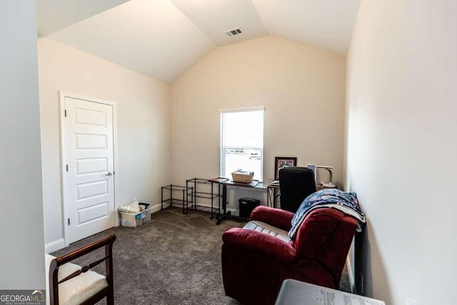 living area with vaulted ceiling and dark colored carpet