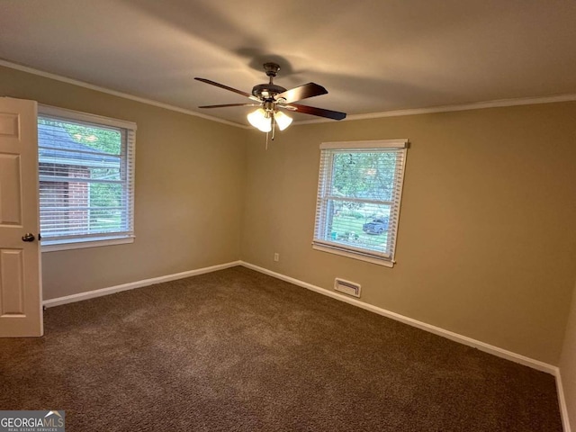 unfurnished room with ceiling fan, ornamental molding, and dark colored carpet