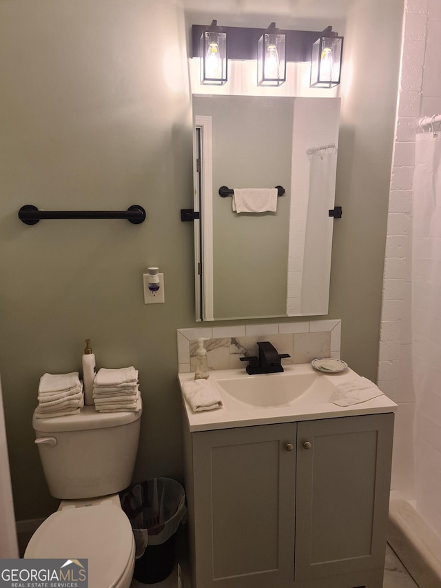 bathroom with tasteful backsplash, vanity, and toilet