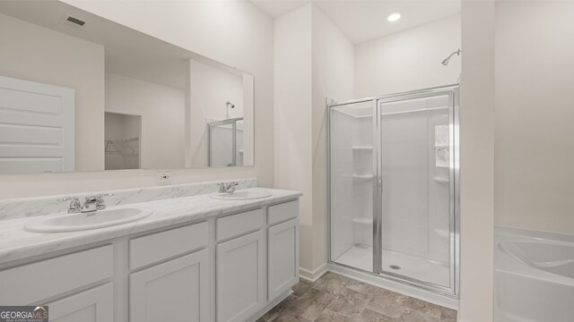 bathroom featuring vanity and shower with separate bathtub