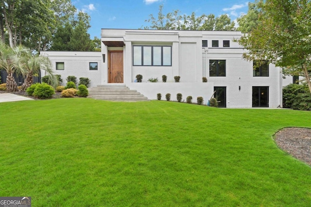 modern home featuring a front lawn