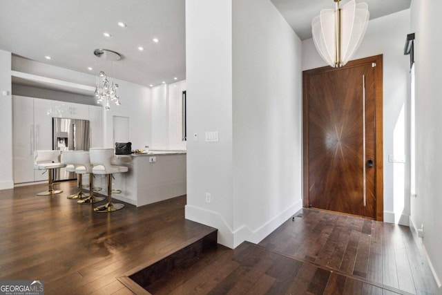 entryway with a chandelier and dark wood-type flooring