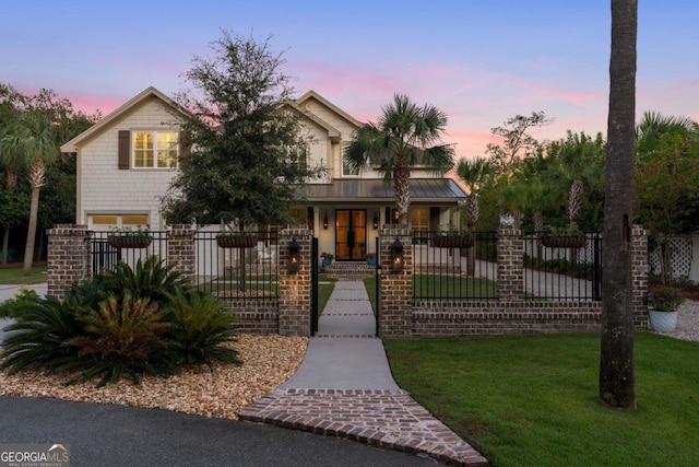 view of front of home featuring a standing seam roof, a lawn, a fenced front yard, and metal roof