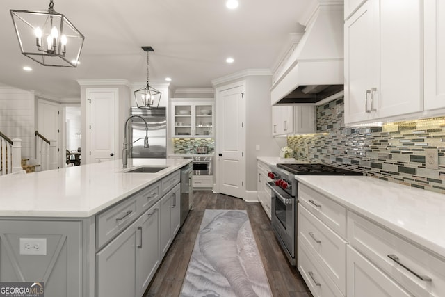 kitchen with white cabinetry, an island with sink, high quality appliances, and premium range hood