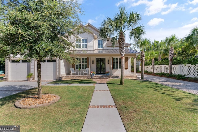 view of front of property featuring a porch, a garage, and a front yard