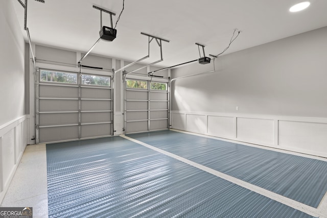 garage with a garage door opener and wainscoting