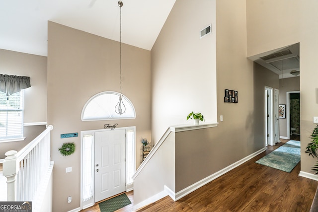 entryway with high vaulted ceiling and dark hardwood / wood-style floors