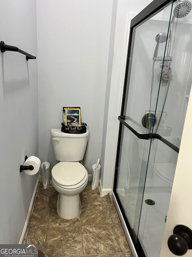 bathroom featuring toilet and an enclosed shower