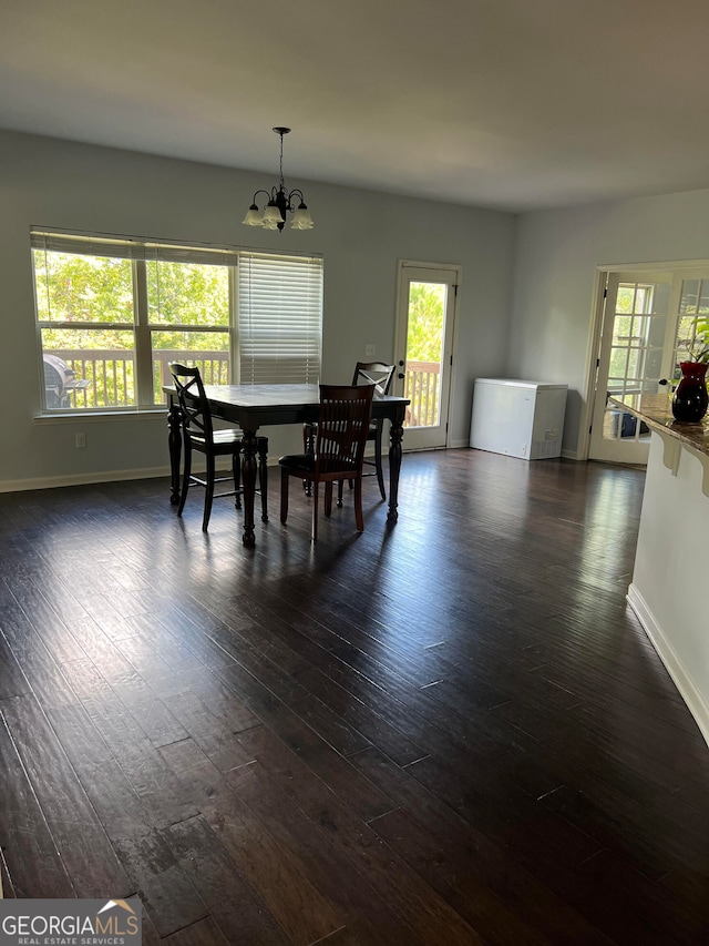 dining area with a notable chandelier and dark hardwood / wood-style floors