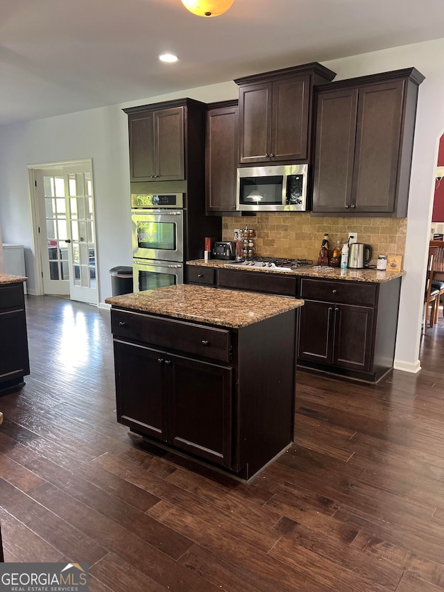 kitchen with backsplash, stainless steel appliances, dark brown cabinetry, and dark hardwood / wood-style flooring