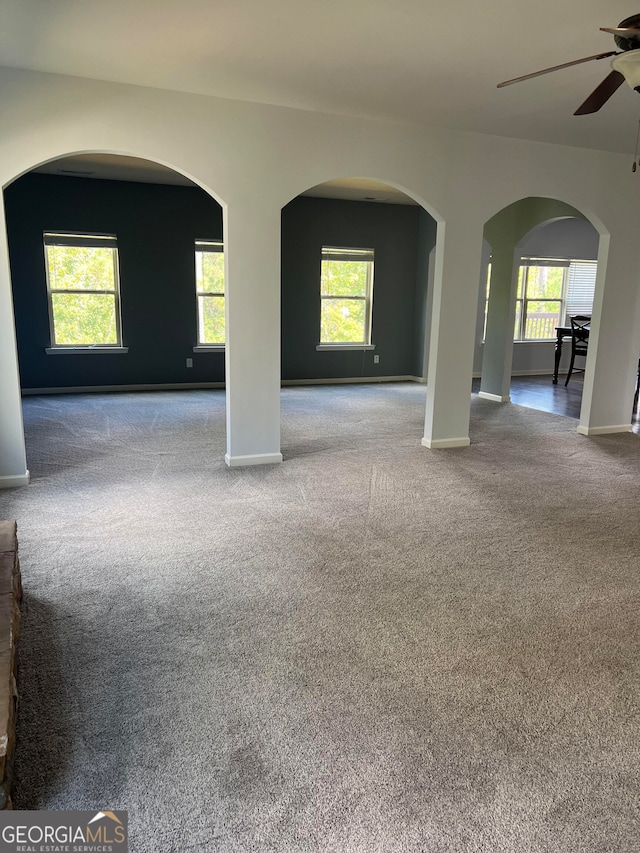 spare room featuring ceiling fan, light colored carpet, and a wealth of natural light