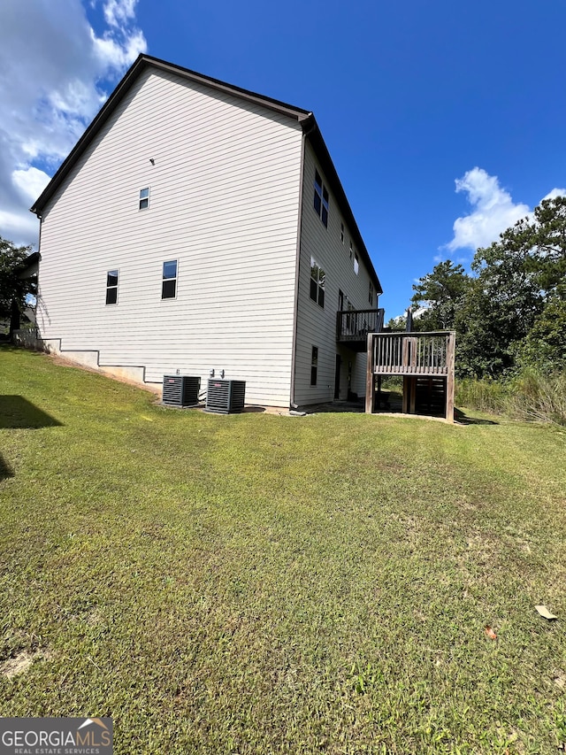 view of side of home featuring a deck, a lawn, and cooling unit