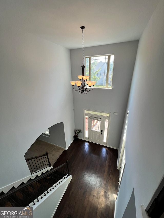 entryway with a notable chandelier and dark hardwood / wood-style floors