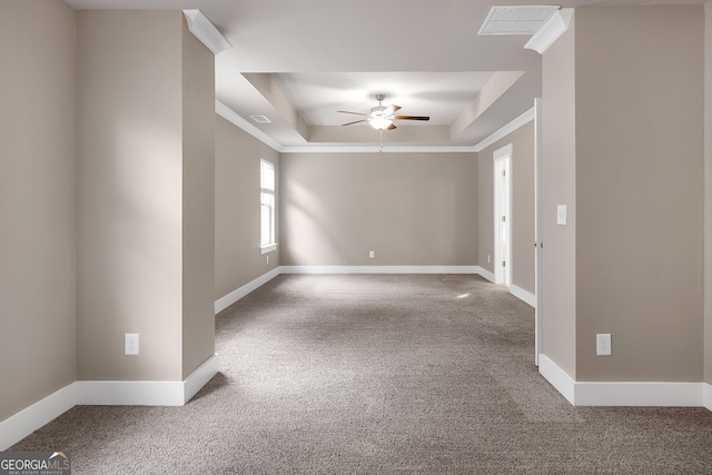 unfurnished room featuring a raised ceiling, carpet, and ceiling fan