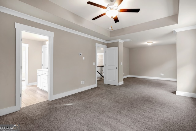 unfurnished room featuring crown molding, a tray ceiling, ceiling fan, and light colored carpet