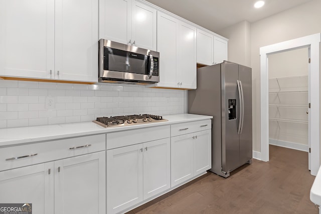 kitchen with light stone counters, light hardwood / wood-style flooring, white cabinetry, stainless steel appliances, and decorative backsplash