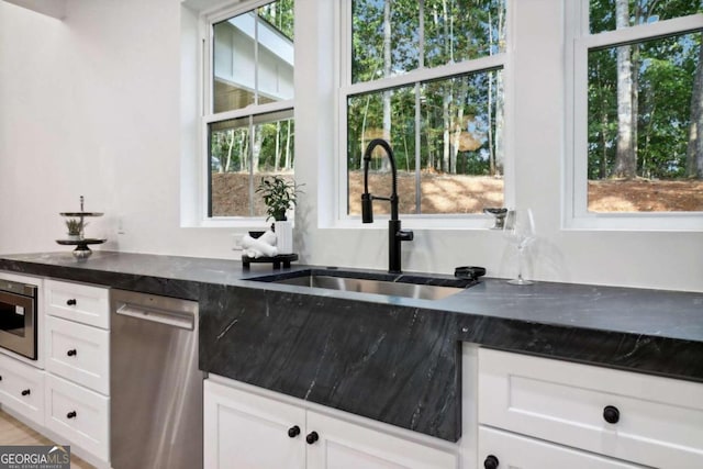 kitchen featuring white cabinets, appliances with stainless steel finishes, and sink