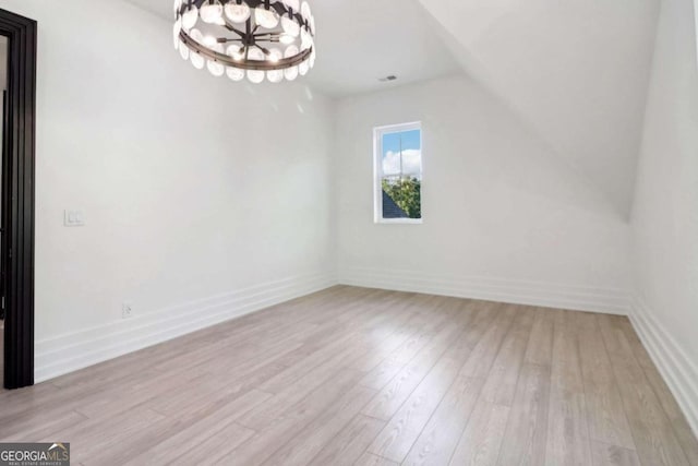 interior space featuring light hardwood / wood-style flooring, a chandelier, and lofted ceiling