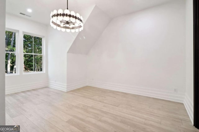 bonus room with a chandelier and light hardwood / wood-style flooring