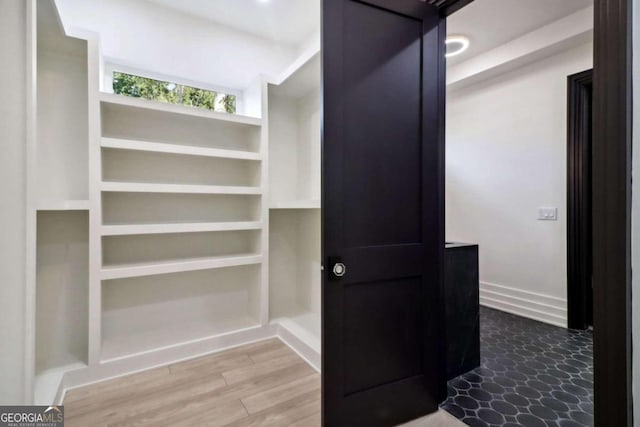 walk in closet featuring a barn door and hardwood / wood-style floors