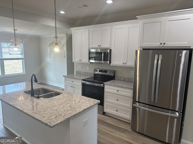 kitchen featuring white cabinets, sink, stainless steel appliances, and a center island with sink