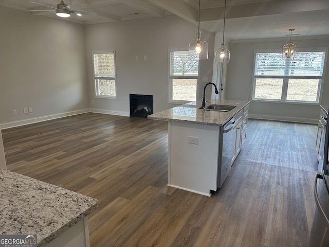 kitchen with light stone counters, sink, decorative light fixtures, a center island with sink, and dishwasher