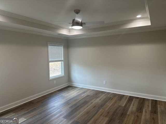 unfurnished room with ceiling fan, dark wood-type flooring, crown molding, and a tray ceiling