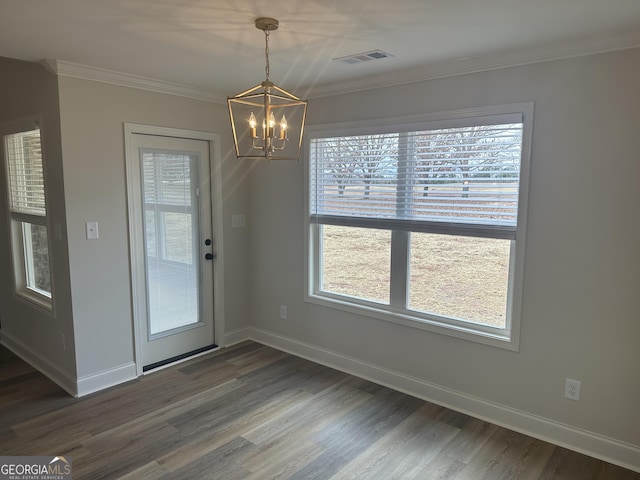 unfurnished dining area featuring crown molding, dark wood-type flooring, and a chandelier