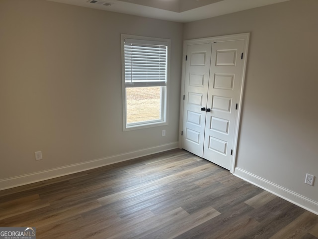 unfurnished bedroom with hardwood / wood-style flooring and a closet