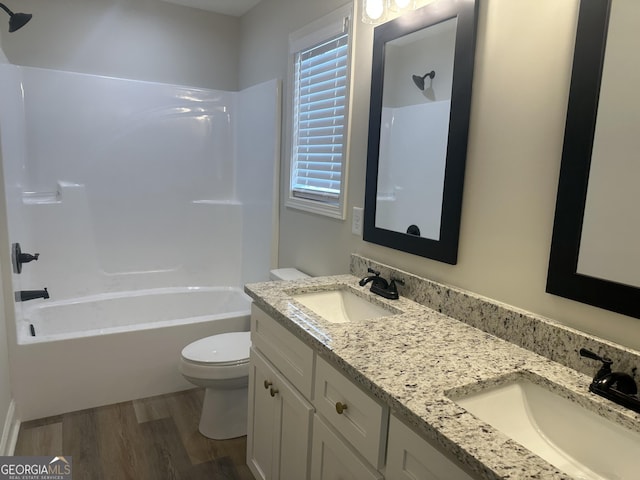 full bathroom with vanity, shower / bath combination, hardwood / wood-style flooring, and toilet