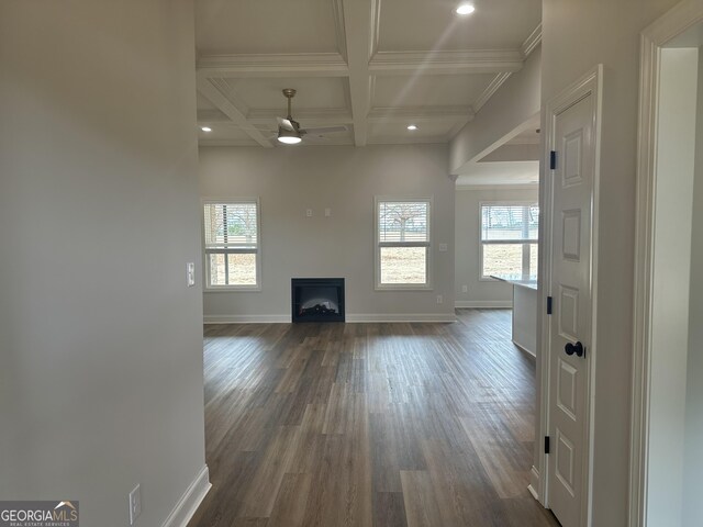 unfurnished living room with ceiling fan, beam ceiling, a healthy amount of sunlight, and coffered ceiling