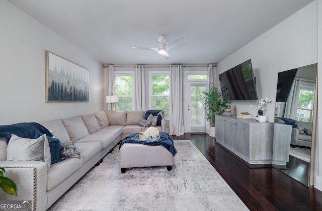 living room with dark hardwood / wood-style flooring and ceiling fan