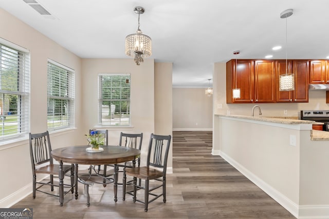 dining space featuring a notable chandelier, dark hardwood / wood-style floors, sink, and plenty of natural light