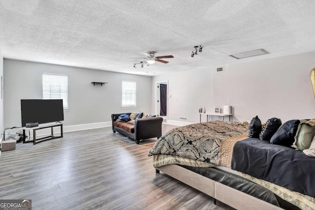 bedroom with a textured ceiling, hardwood / wood-style floors, and ceiling fan