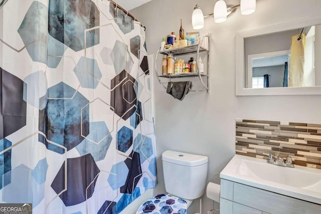 bathroom featuring curtained shower, vanity, and toilet