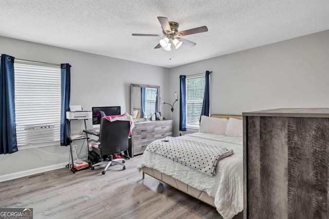 bedroom featuring wood-type flooring, a textured ceiling, and ceiling fan