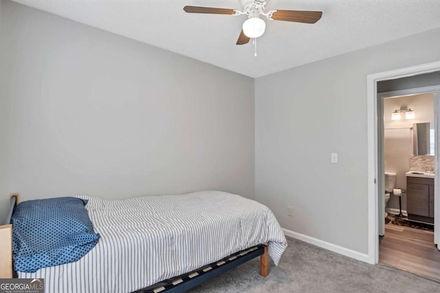 carpeted bedroom with connected bathroom and ceiling fan