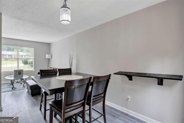 dining space with a textured ceiling and hardwood / wood-style floors