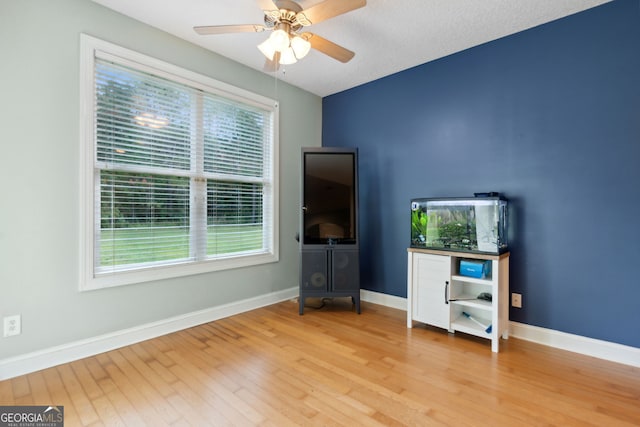 interior space featuring ceiling fan, a textured ceiling, and light hardwood / wood-style flooring