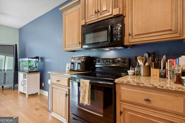 kitchen with a textured ceiling, black appliances, light hardwood / wood-style floors, and light stone countertops