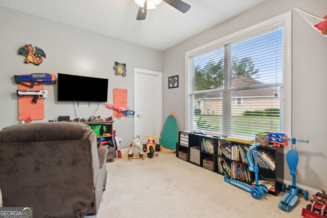 playroom featuring carpet, ceiling fan, and a healthy amount of sunlight