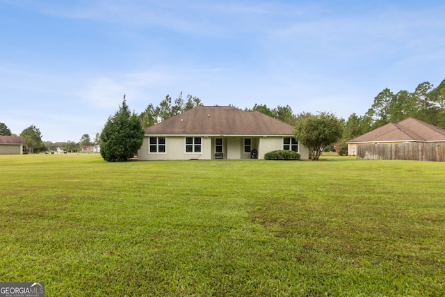 rear view of property featuring a yard