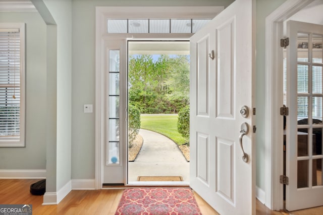 foyer featuring light wood-type flooring and crown molding