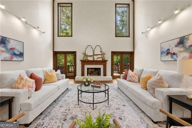 living room with plenty of natural light, french doors, and light hardwood / wood-style flooring