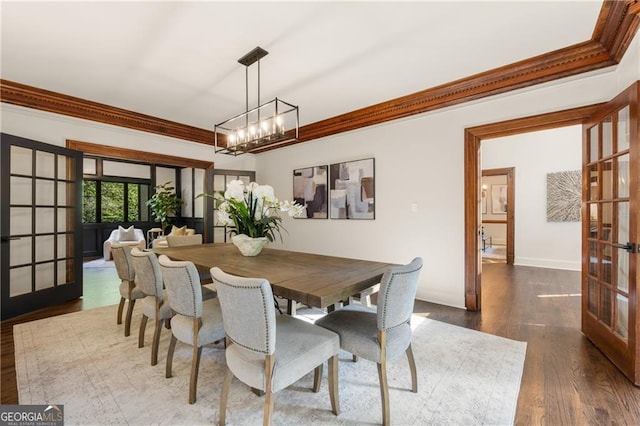 dining area featuring french doors, a notable chandelier, dark hardwood / wood-style floors, and ornamental molding