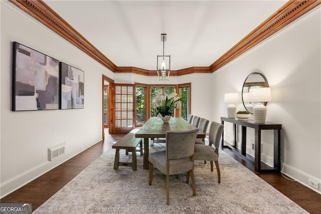 dining room with crown molding and dark wood-type flooring