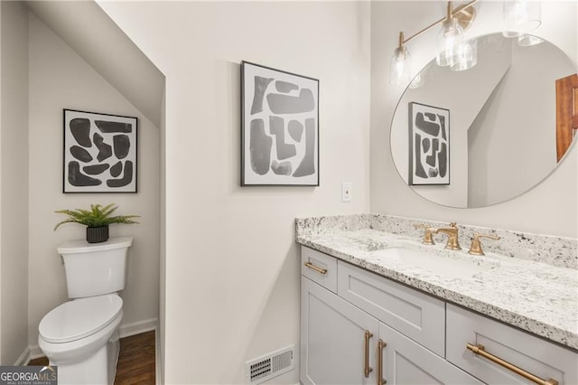 bathroom featuring vanity, toilet, and wood-type flooring