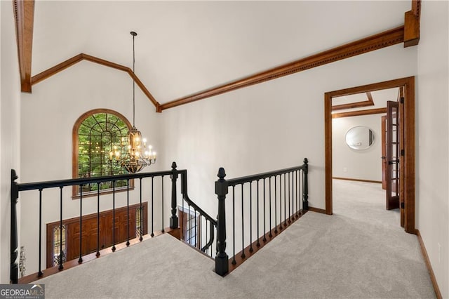 hallway with carpet floors, a notable chandelier, and high vaulted ceiling