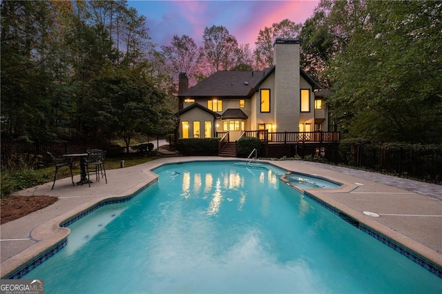 pool at dusk featuring a patio